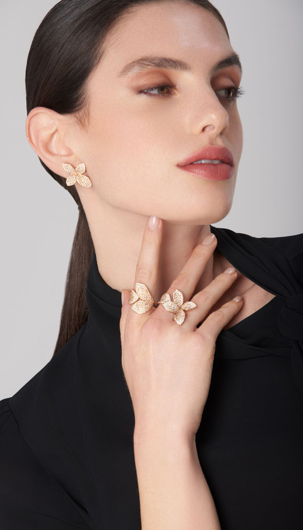 Earrings and rings in 18k gold with pavé diamonds on model wearing black blouse