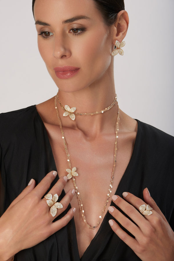 Sautoir, rings and earrings in 18k Rose Gold with White and Champagne Diamonds on model wearing a V neck dress