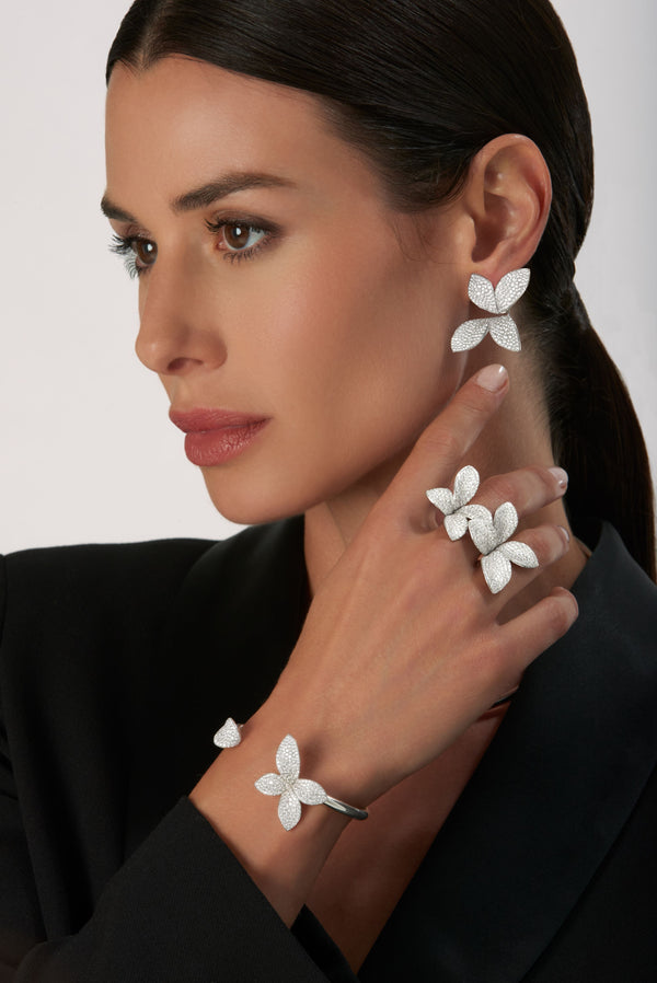 Flower Earrings, rings and bracelet in 18k White Gold with Diamonds on model wearing a black jacket