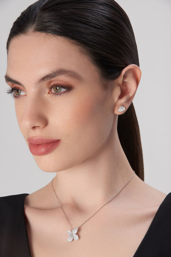 Necklace with butterfly pendant and stud earrings in 18k white gold with diamonds, worn by model in black dress