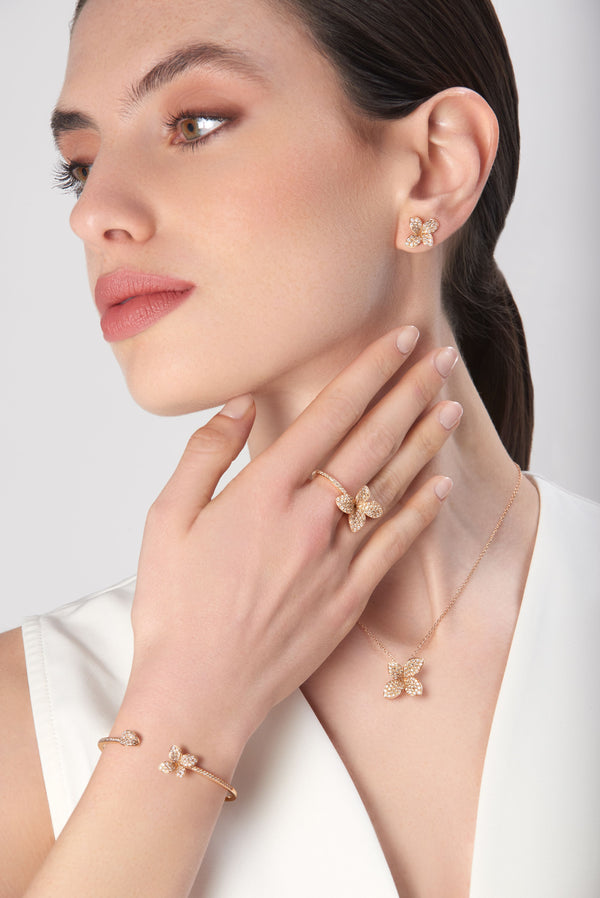 Earrings, bracelet and ring in 18k rose gold with diamonds on model in white dress