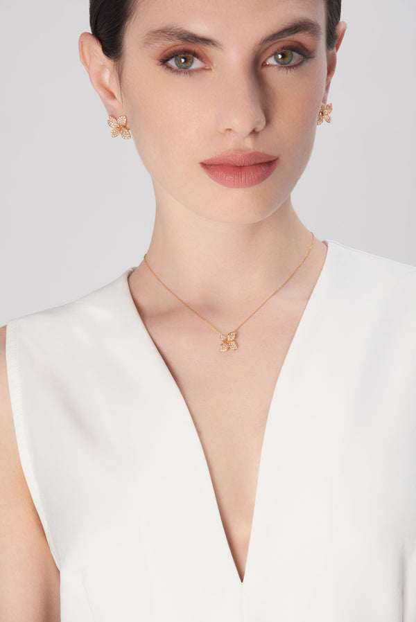 Earrings and necklace in 18k rose gold with diamonds on model in white dress