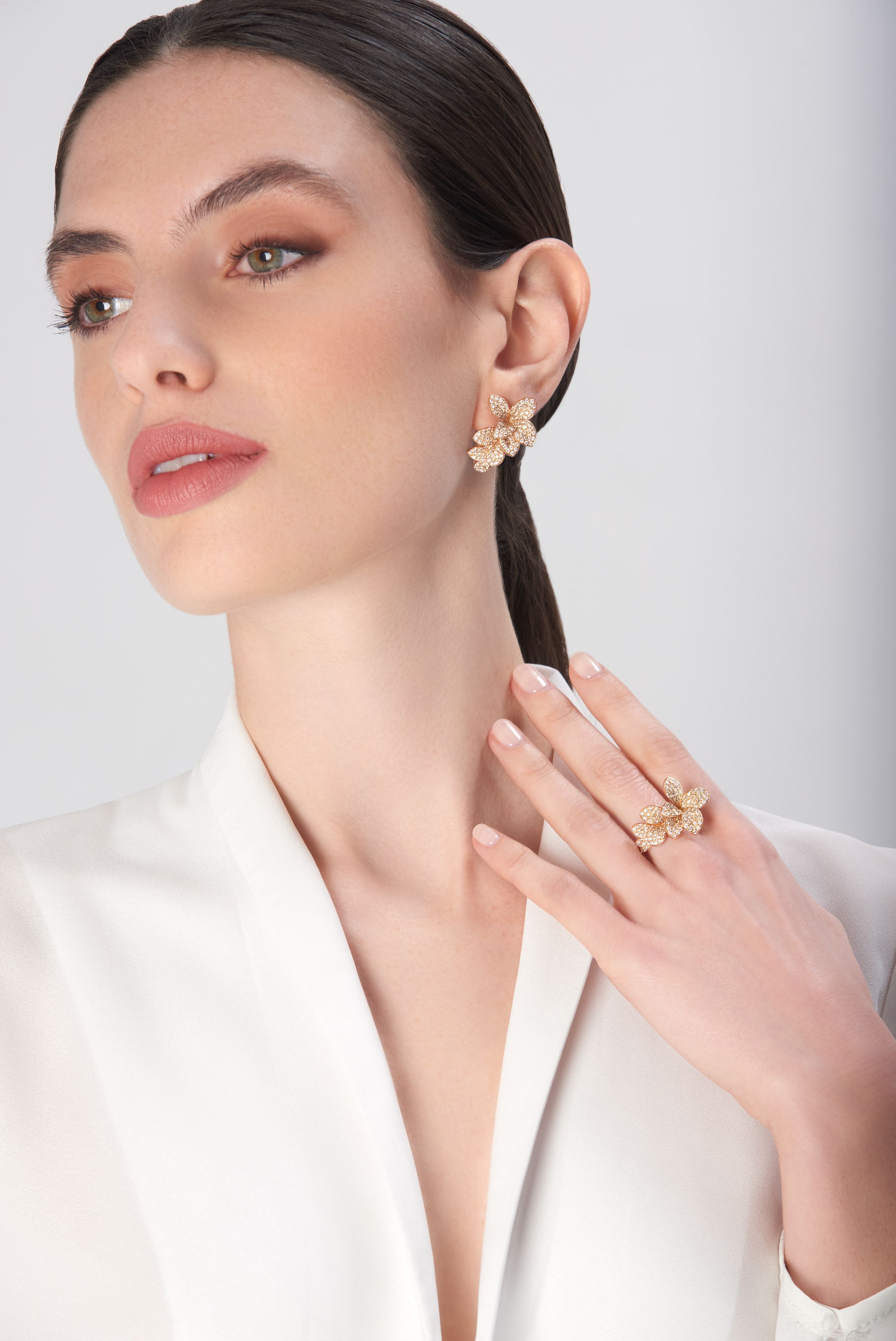 Earrings and ring in 18k rose gold with diamonds on model in white dress