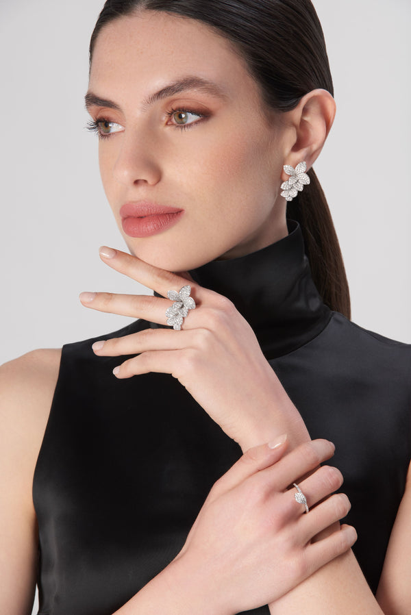 Earrings and rings in 18 k white gold with diamonds worn by a model in a black satin turtleneck dress