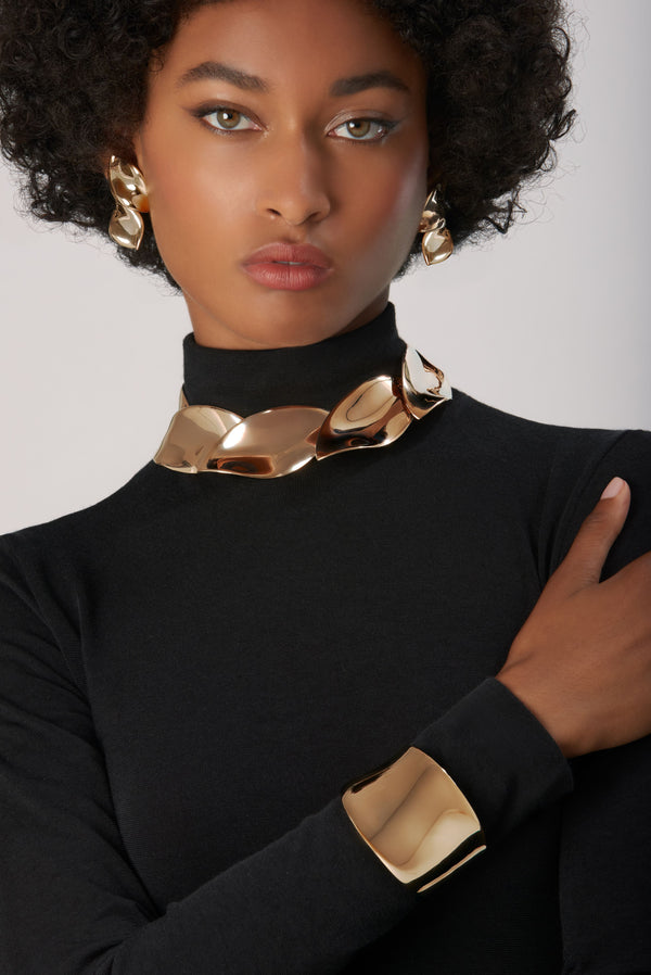 Bracelet, necklace and earrings in 18k Rose Gold on model wearing black turtleneck