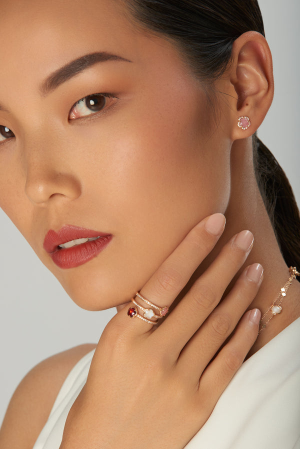 Stud earrings and rings in 18k rose gold with stones and diamonds on model in white dress