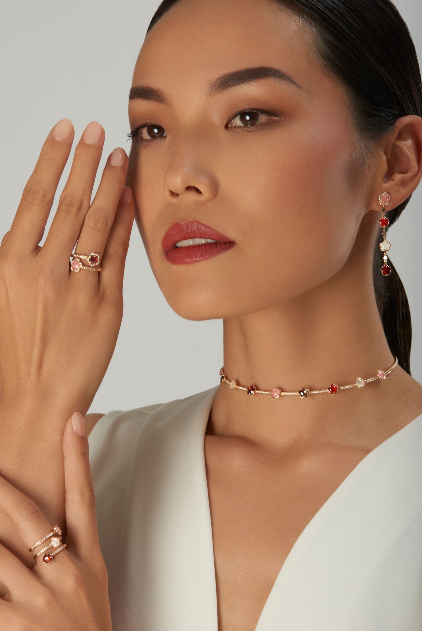 Choker, rings earrings in 18k rose gold with gemstones and diamonds on model in white dress