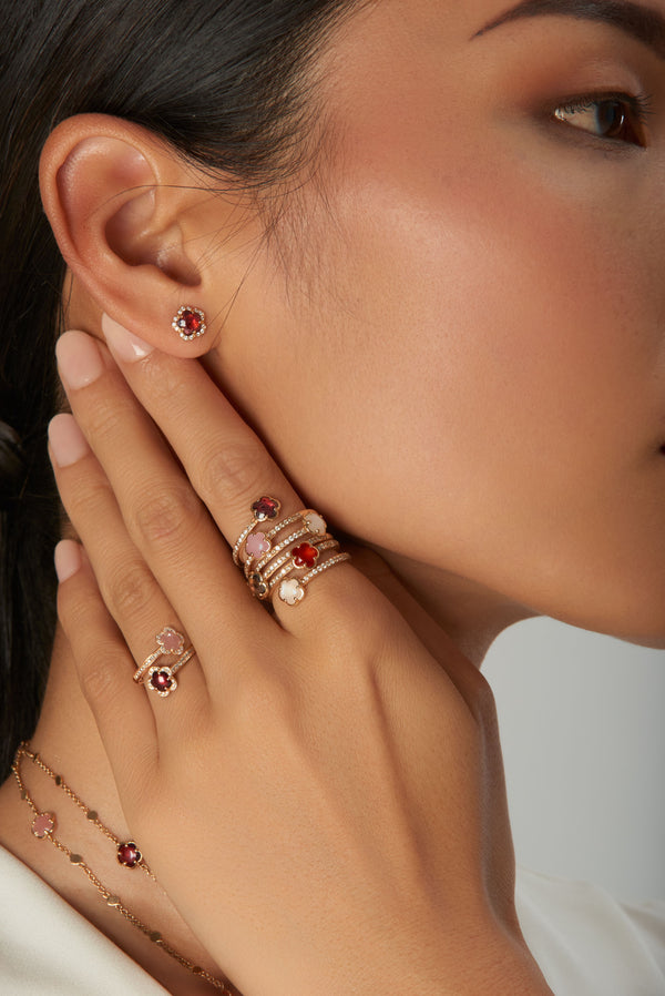Earrings and rings in 18k rose gold with red and white stones and  white and champagne diamonds on model