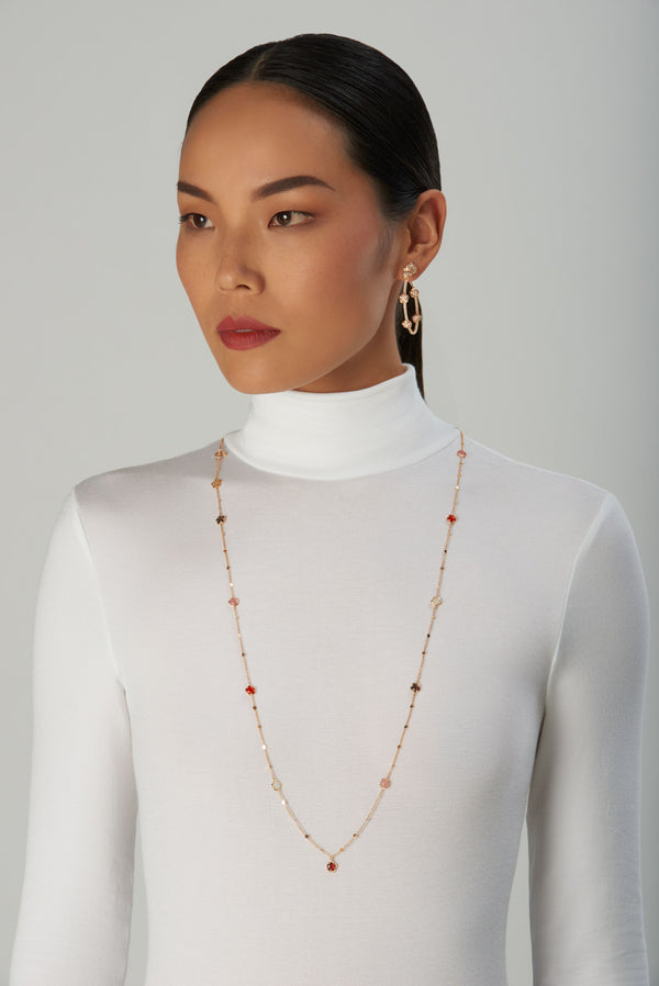 Necklace and earrings in 18k rose gold with diamonds on model in white turtleneck