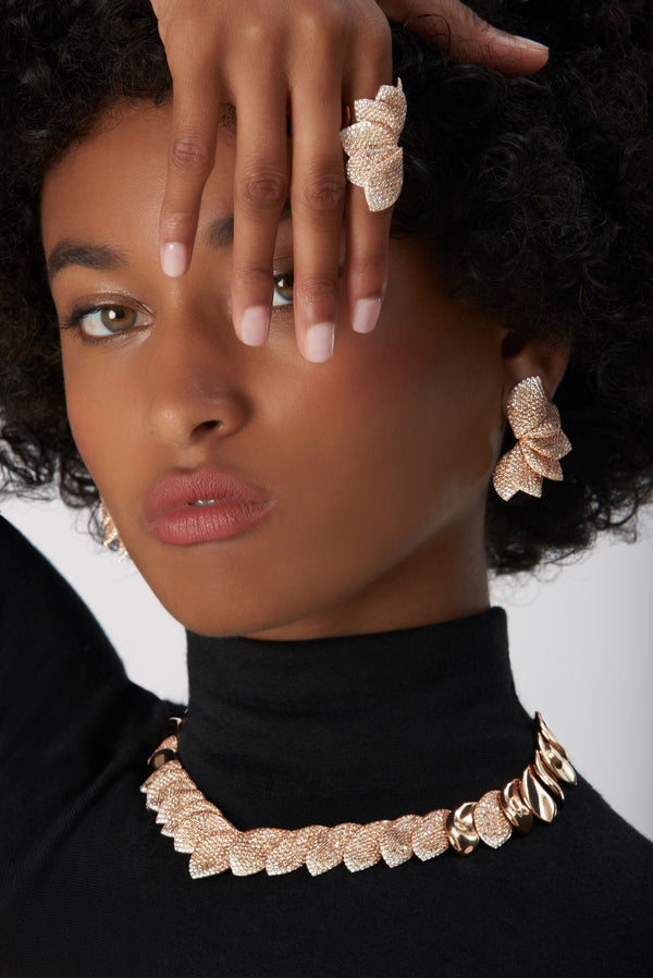 Ring, earrings, necklace in 18k Rose Gold with White and Champagne Diamonds on model wearing a black turtleneck