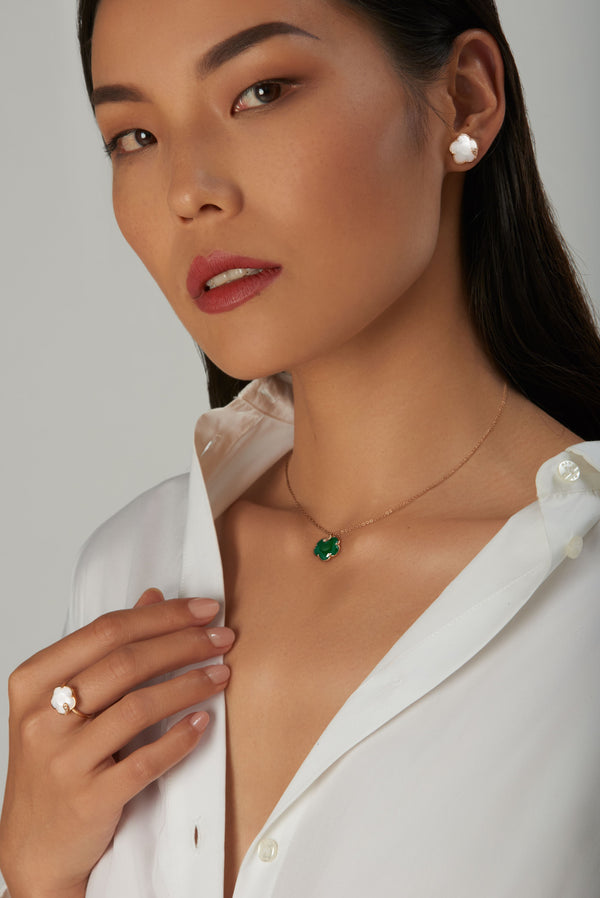 Necklace with emerald and mother-of-pearl earring and ring on model in white shirt