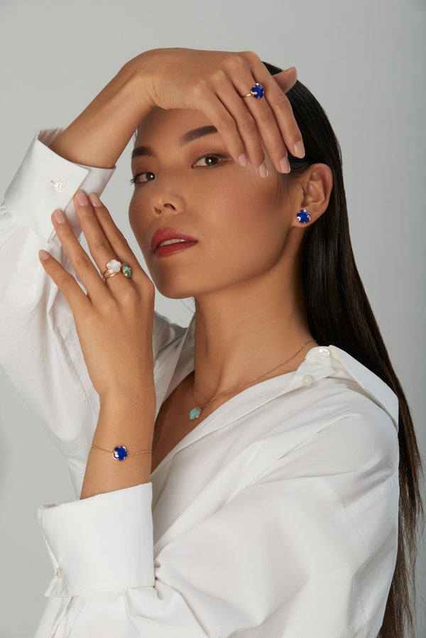 Necklace, earrings, rings in 18k rose gold with coloured gemstones and diamonds on model in white shirt