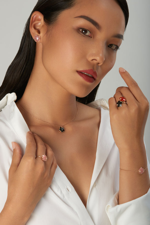 Jewelry set: necklace, earrings, rings and bracelet with gemstones on model wearing white shirt