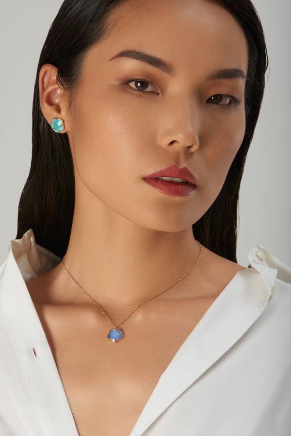Necklace and stud earrings in 18k gold with turquoise worn by model in white blouse