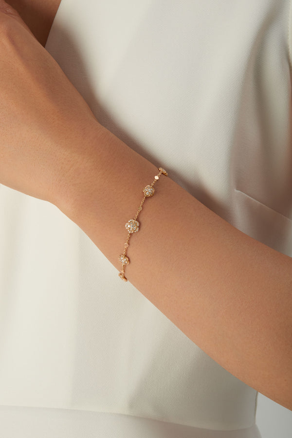 Bracelet in 18k rose gold with diamonds on woman's wrist in white dress