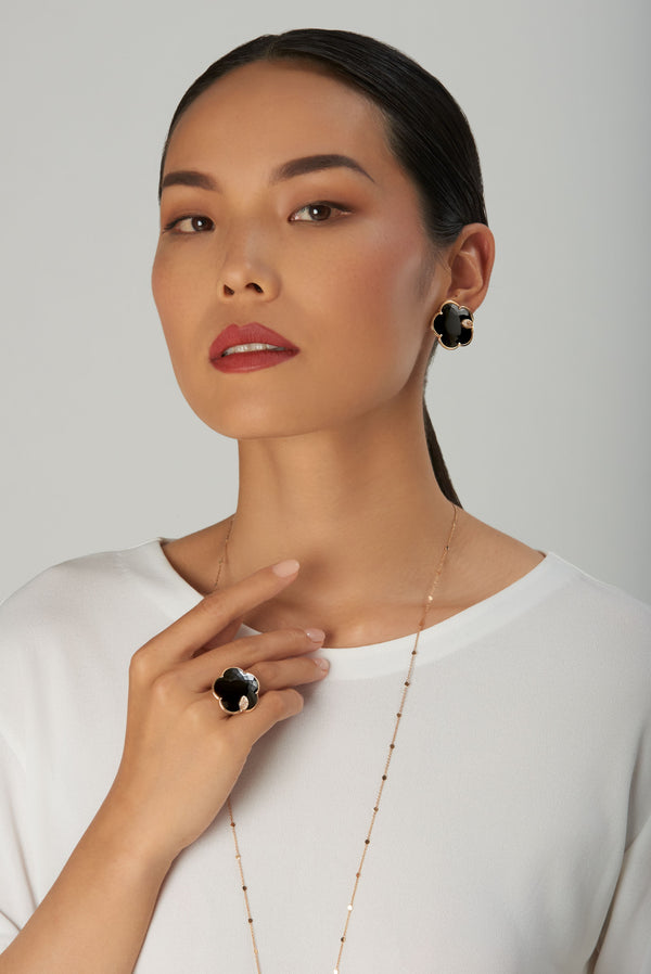 Earring and ring in 18k rose gold with onyx, white and champagne diamonds, worn by model in white blouse