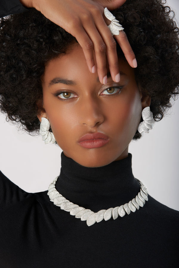 Earrings, rings and necklace in 18k White Gold with Diamonds on model wearing black turtleneck