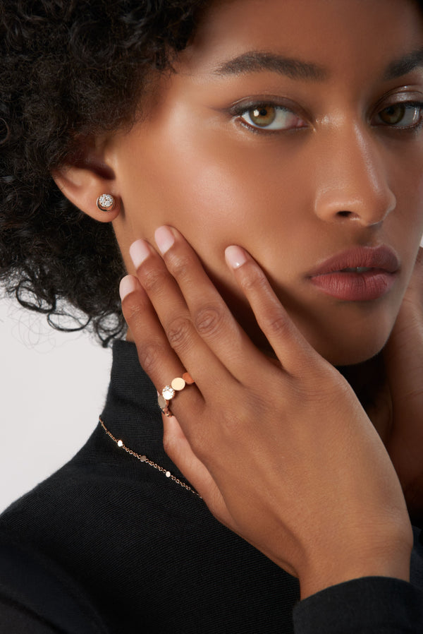 Earrings and rings in 18k Rose Gold with Diamonds on model wearing black turtleneck