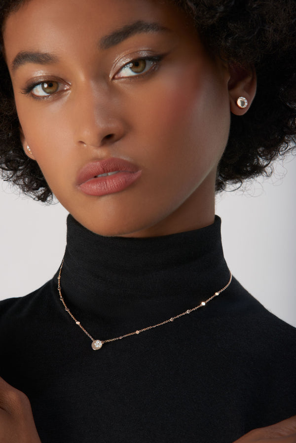 Necklace and earrings in 18k Rose Gold with Diamonds on model wearing black turtleneck