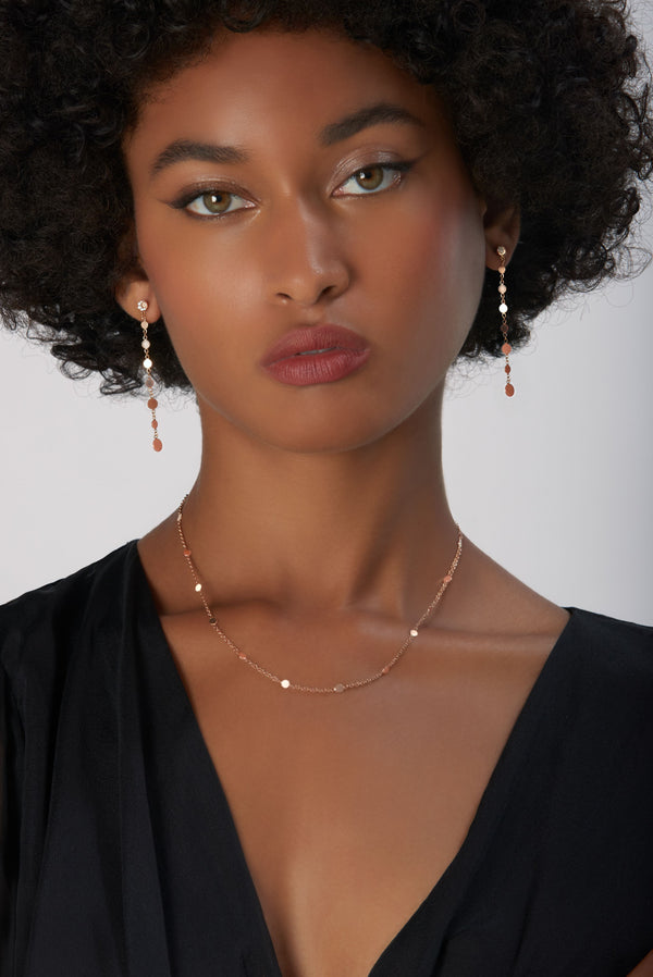Chain and earrings in 18k Rose Gold on model wearing a black dress