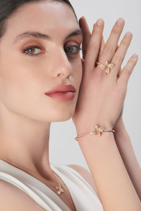 Necklace, bracelet, and rings in 18k rose gold with diamonds on model in an ivory dress