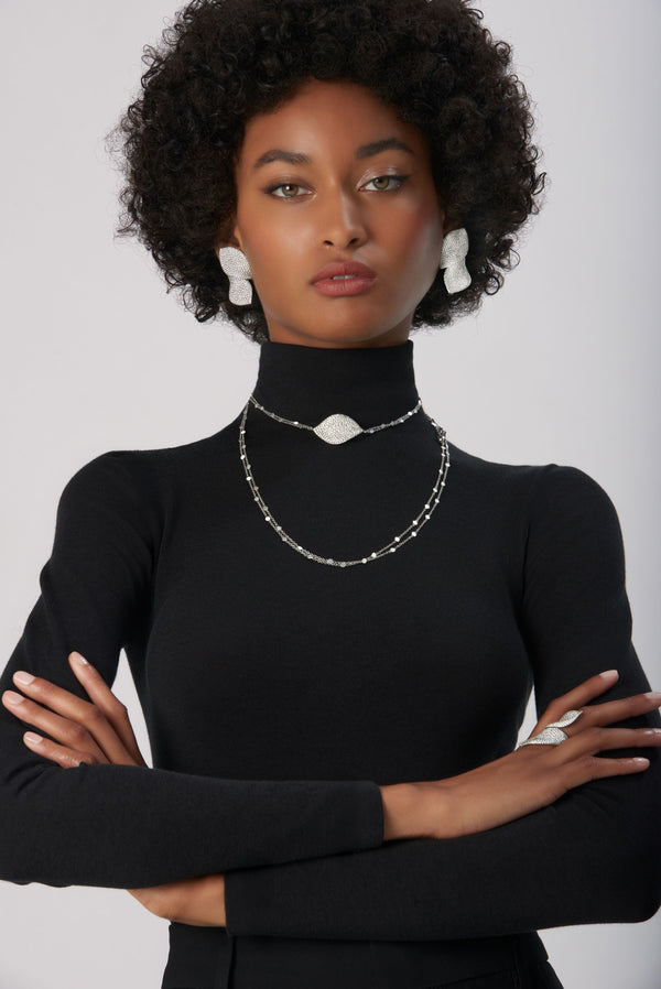 Sautoir, ring and earrings in 18k White Gold with White Diamonds on model wearing black turtleneck