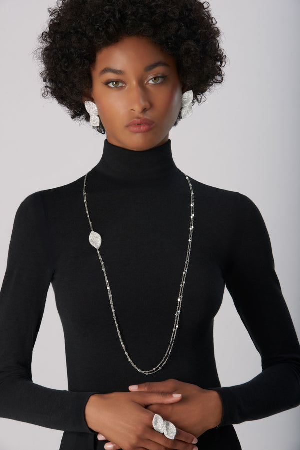 Leaf-shaped jewelry set in 18k white gold with diamonds worn by model
