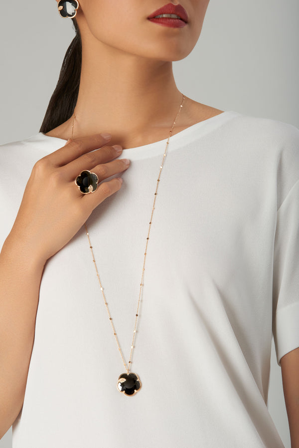 Necklace, earrings, and ring in 18k gold with black onyx on model in white blouse
