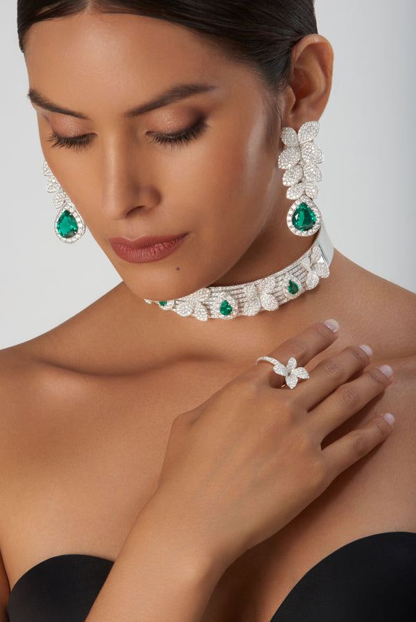 Necklace, earrings, bracelet, ring in 18k white gold with emeralds and diamonds on model in black gown