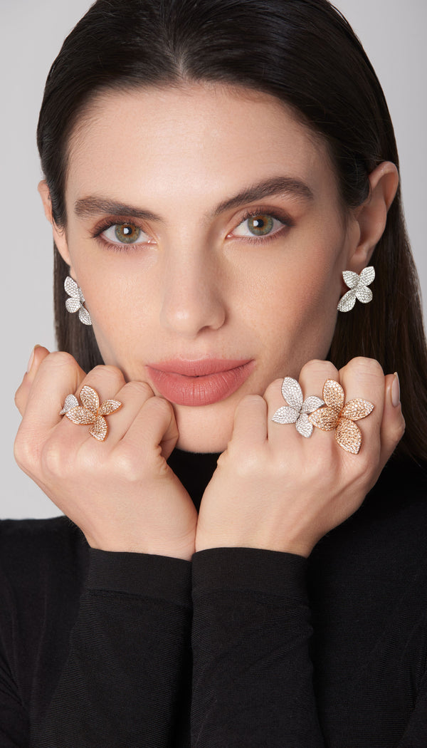 Earrings and rings in 18k rose and white gold with diamonds on model in black turtleneck