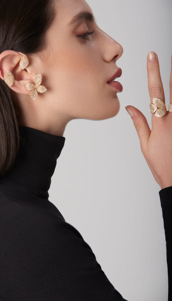 Ear cuff, earring and ring in 18k rose gold with diamonds, modeled in profile wearing a high-neck black garment
