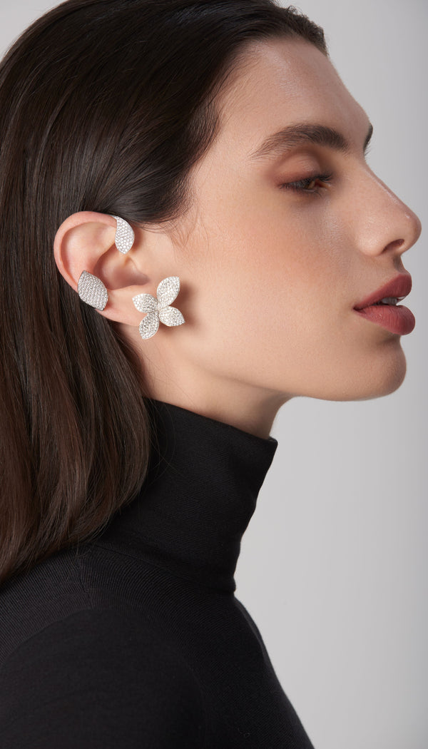 Ear cuff and stud earring in white gold with diamonds on model in black turtleneck