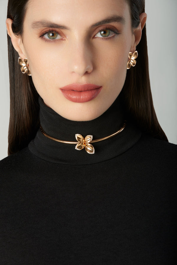 Necklace and earrings in 18k rose gold with diamonds worn by model in black turtleneck 