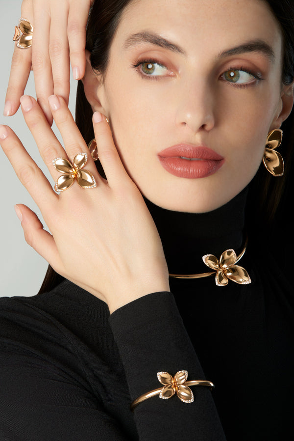 Necklace, bracelet, earrings and rings in 18k rose gold with diamonds on model in black turtleneck