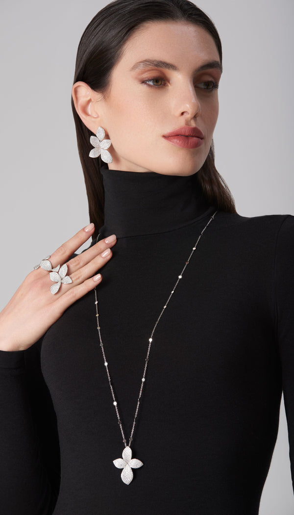 Necklace, earrings, rings in 18k white gold with diamonds on model in black turtleneck
