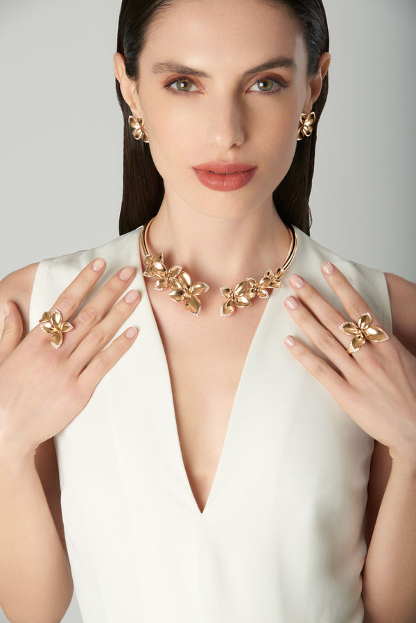 Necklace, earrings and rings in 18k rose gold with diamonds on model with a white dress