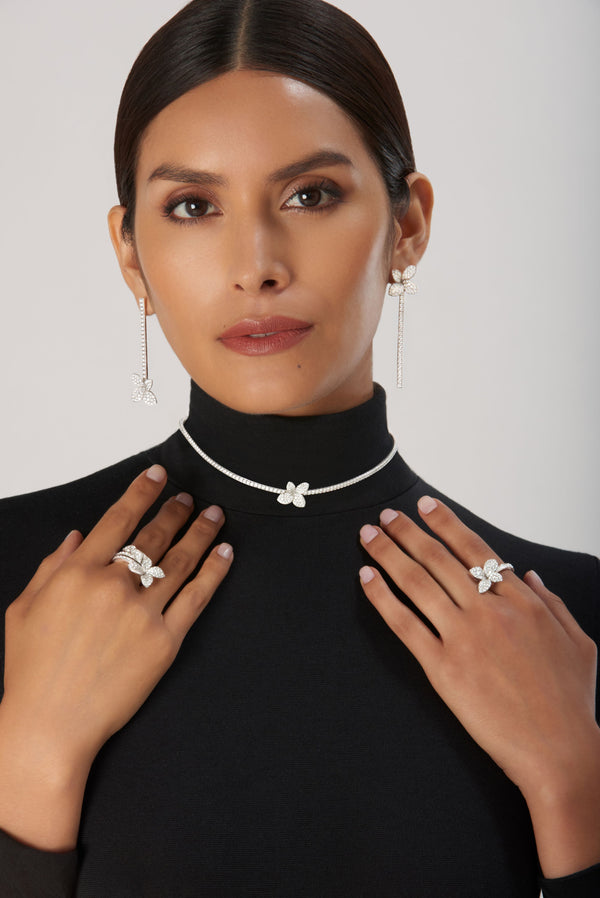 Jewelry set: earrings, necklace and rings in 18k white gold with diamonds on woman wearing black turtleneck