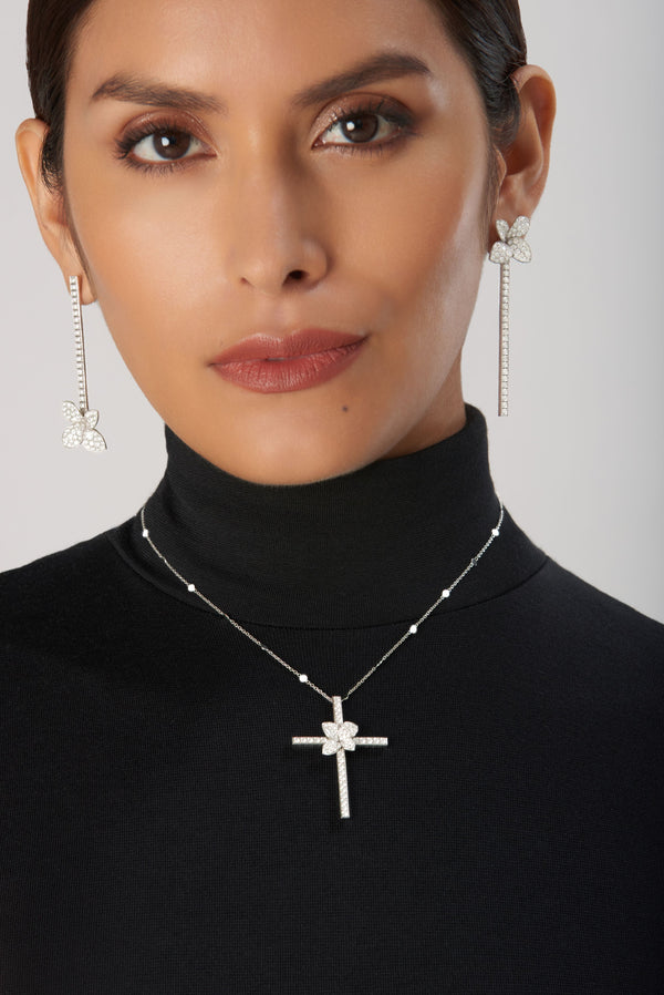 Dangle earrings and necklace in 18k white gold with diamonds on model wearing turtleneck