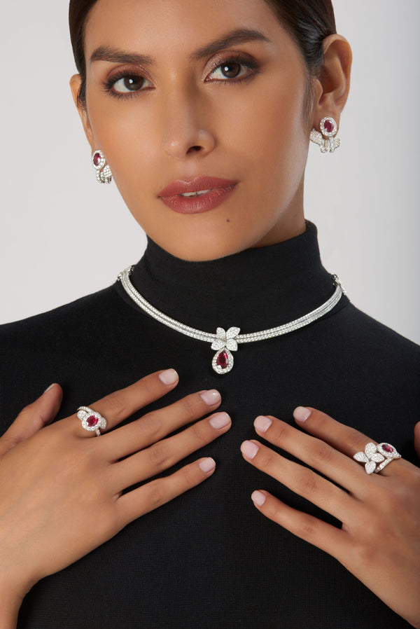Jewelry set for women: earrings, necklace and rings in 18k white gold with rubies and diamonds on model