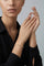 Model wearing a Bracelet in 18k Rose Gold with White and Champagne diamonds and a black shirt