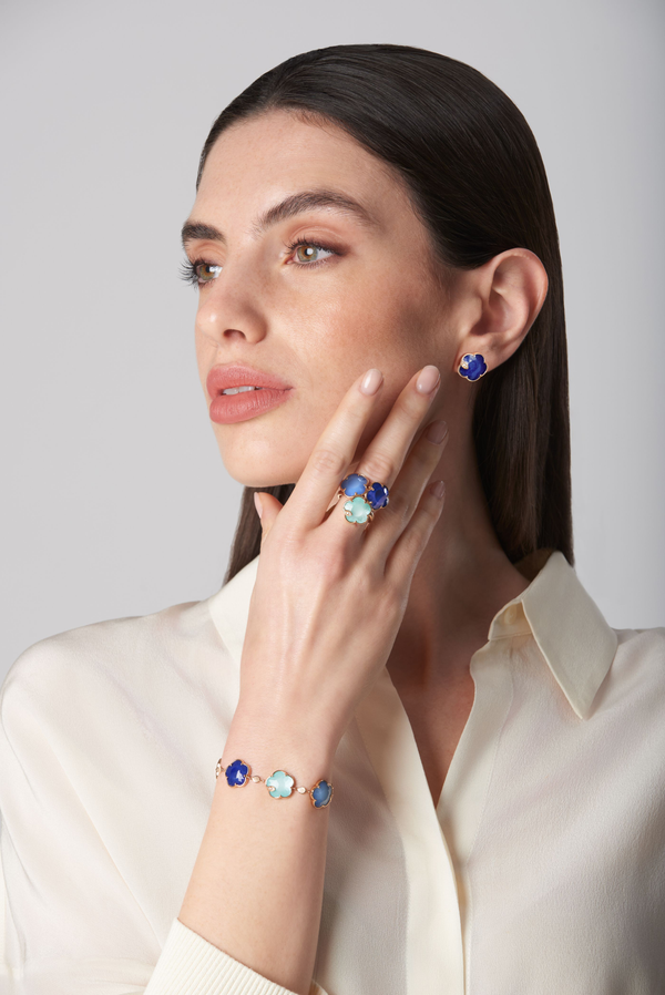Bracelet, ring, and stud earrings with lapis lazuli and diamonds in 18k rose gold, worn by a model in cream blouse