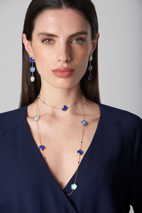Pendant earrings and necklace in 18k rose gold with blue stones and diamonds on model in dark blue dress