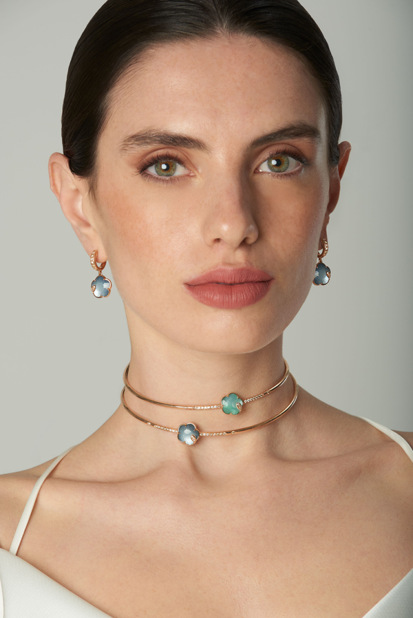 Earrings and choker with gemstones and diamonds in 18k rose gold on model wearing white dress