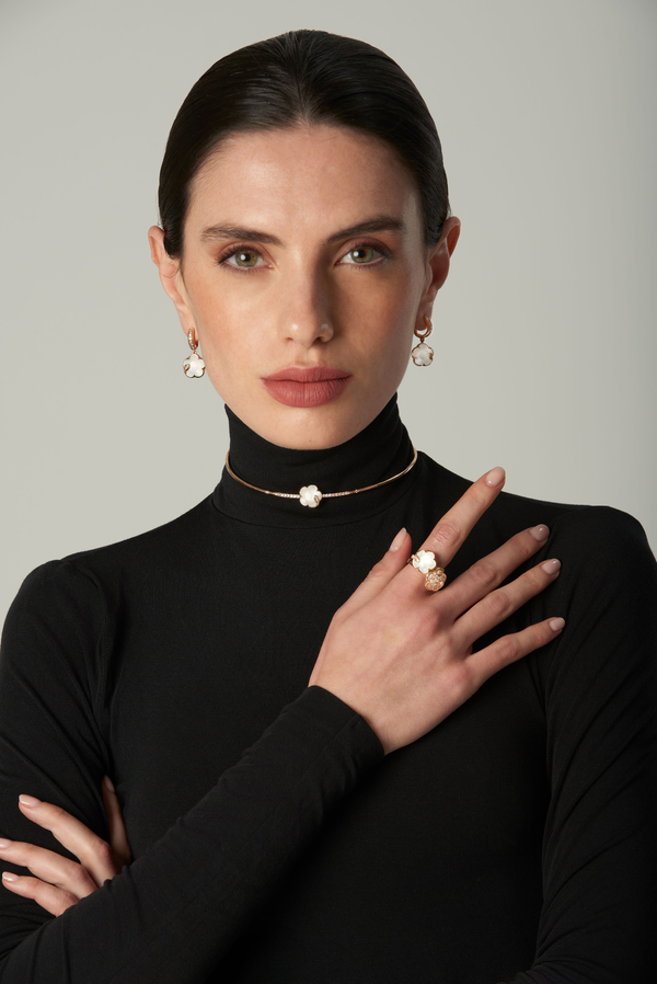 Necklace, earrings, and ring in 18k rose gold with pearl gem and diamonds on model in black turtleneck