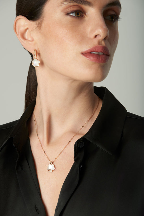 Earrings and necklace in 18k rose gold with pearl gem and diamonds on model in black shirt