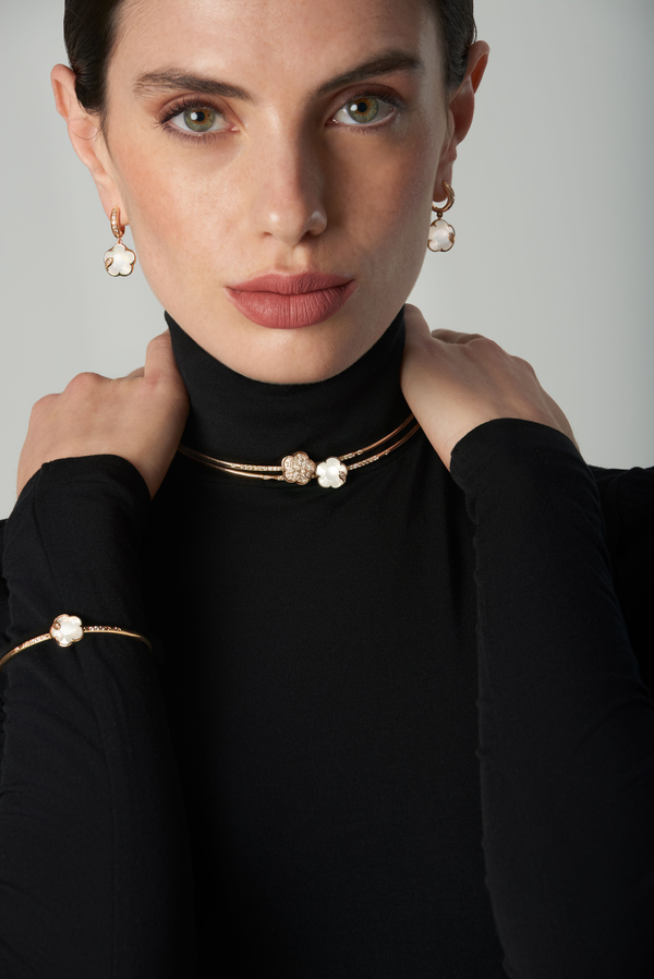 Earrings, choker, and bracelet in 18k rose gold with gem pearl and diamonds on woman in black turtleneck