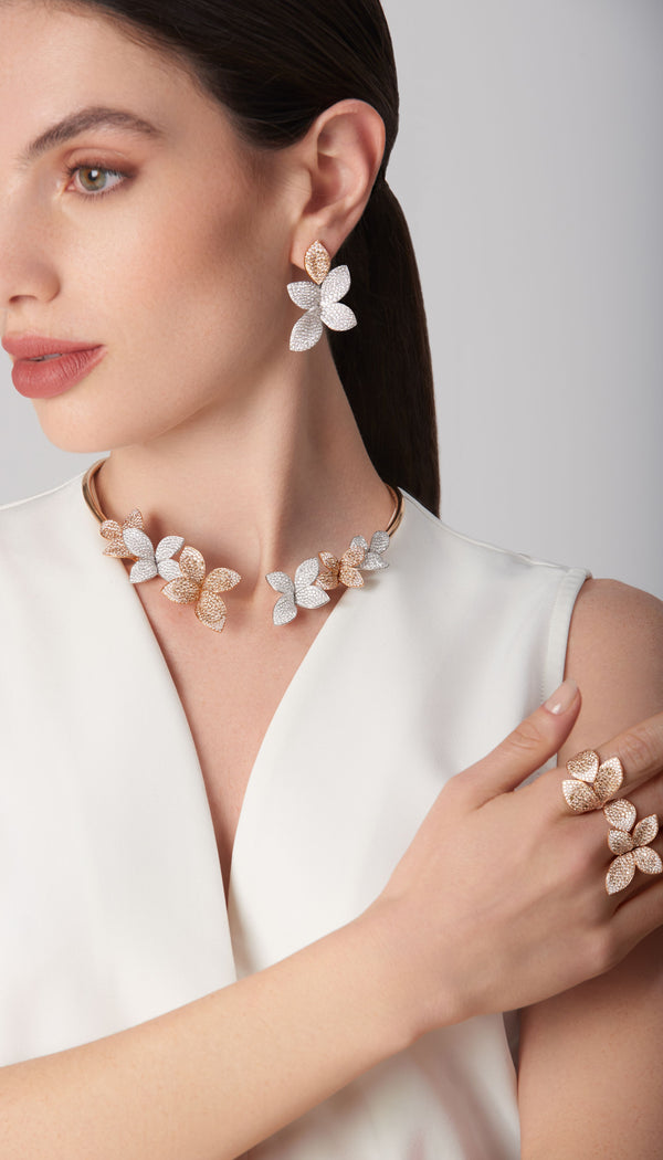 Choker, earrings, and ring in 18k white and rose gold with diamonds on model in white dress