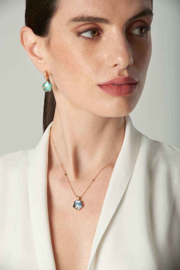Necklace and earrings in 18k rose gold colured gems and diamonds on model in white silk blouse