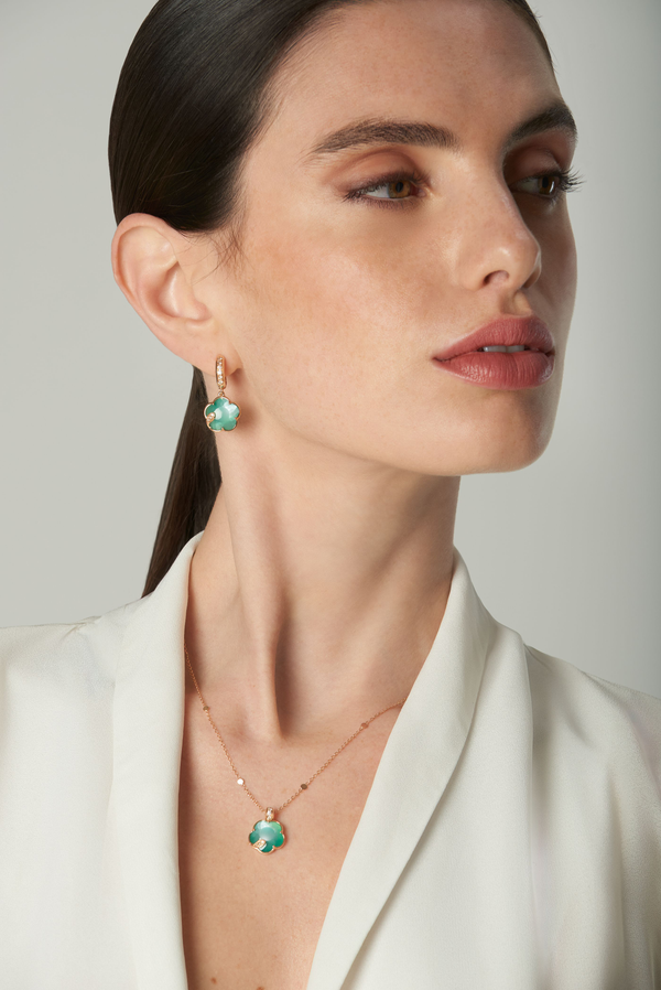 Necklace and earrings in 18k rose gold with green gemstones and diamonds on model in white blouse