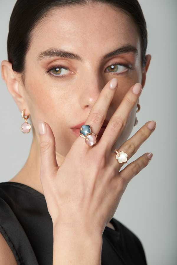 Earrings and rings in 18k rose gold with coloured gemstones and diamonds on model in black dress